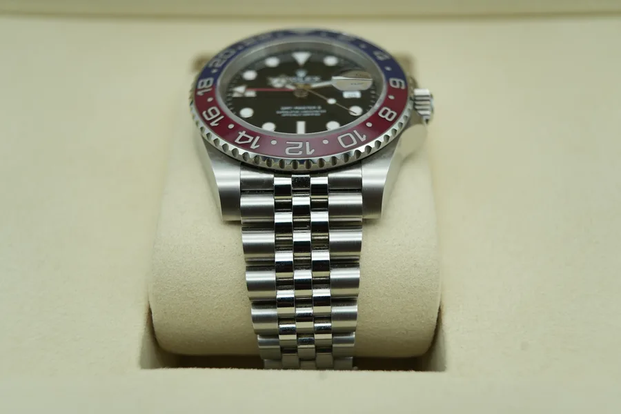 Rolex GMT-Master II with a red and blue ceramic bezel, photographed from above on a neutral background.
